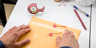 Man sealing an envelope with Scotch® Super-Hold Tape
