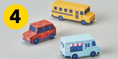 Step 4 - three paper cars on a table

