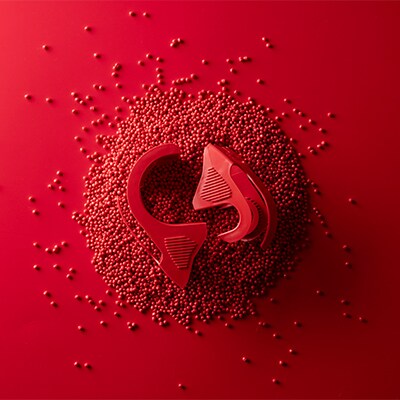 Red Scotch™ Packaging tape dispenser on a red background of red beads of recycled plastic