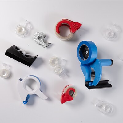 A variety of tape dispensers on a white background.