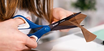 Girl cutting paper with Scotch™ Scissors
