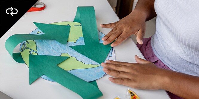 A child crafting a paper world map with tape from Scotch™ Brand
