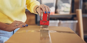 Woman sealing a box with Scotch® Packaging Tape
