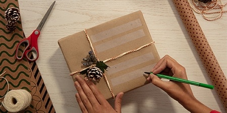 Creating gift labels using Scotch® Magic™ Tape on a gift wrapped with plain packaging paper
