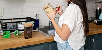 Woman creating DIY labels from Scotch® Magic™ Tape and putting them on food containers
